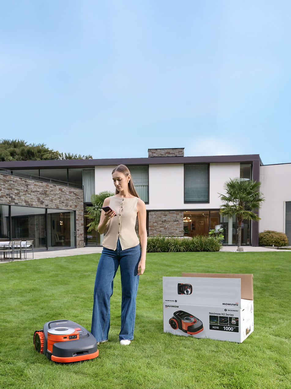 Segway Navimow H210 robot lawn mower on a green lawn.
