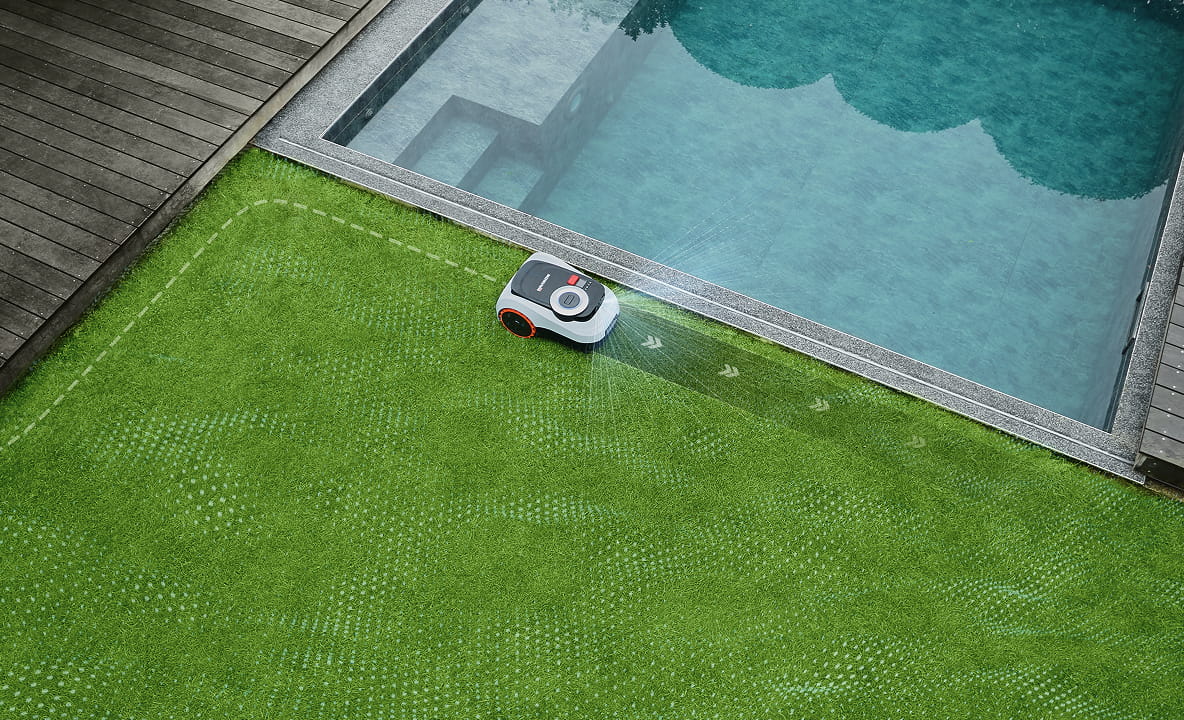 Segway Navimow i105E robot lawn mower mows grass near pool.