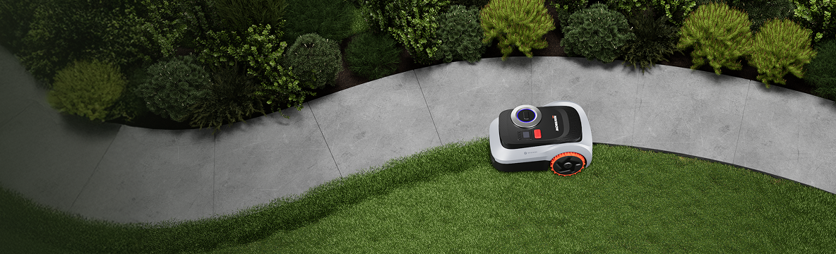 Navimow i110 robot lawn mower trims grass along a path.