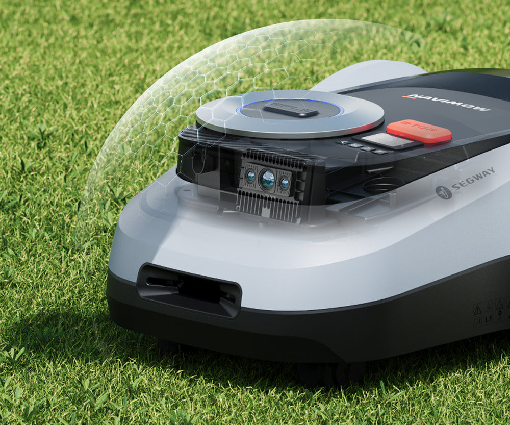 The Segway Navimow robot lawn mower sits on green grass.