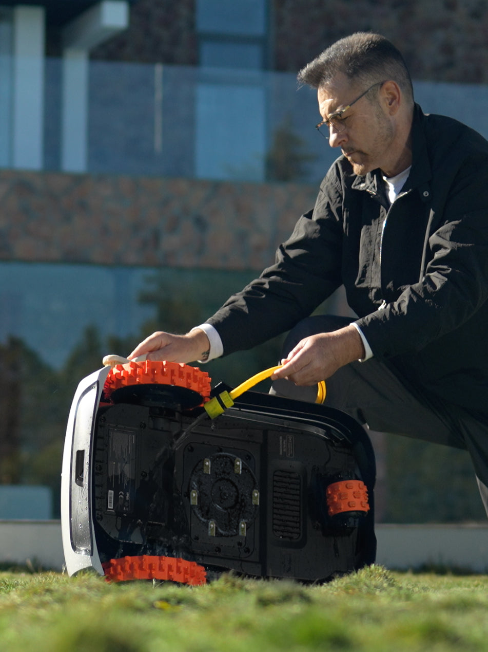 Navimow i105E robot lawn mower being washed by a man.