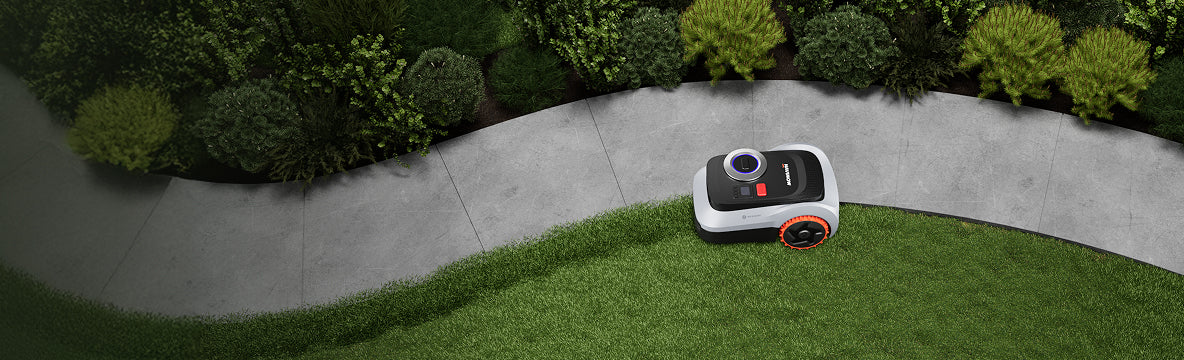 Navimow i105E robot lawn mower mows grass along the path.